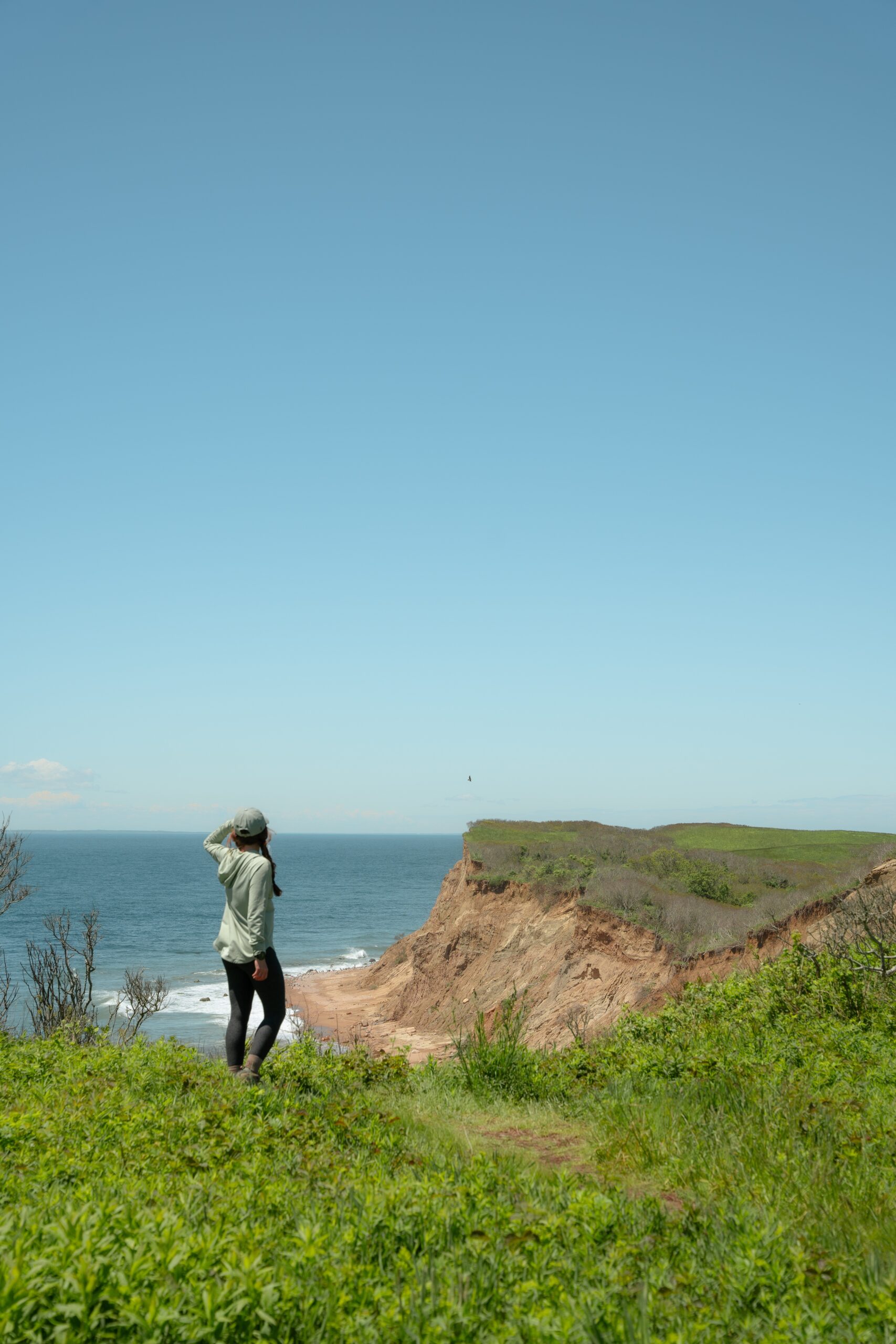 best coastal hikes in rhode island woman overlooking the ocean on a hike